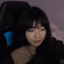 a woman is sitting in a chair with her eyes closed and looking at the camera .
