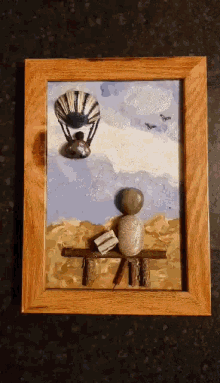a painting of a person sitting on a bench with a book and a hot air balloon