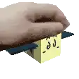 a hand is holding a yellow box with the letter j on it