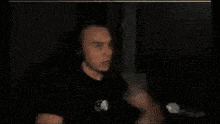 a blurry picture of a man in a dark room with a ghost behind him