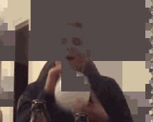 a man is holding a light bulb in front of a mirror .