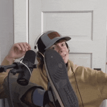 a man wearing headphones and a hat holds up his shoe