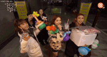 a group of girls holding balloons and drinks in front of a sign that says honeycam org