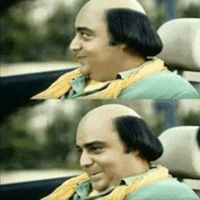 a man with a bald head is sitting in a car .