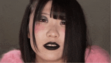 a close up of a woman 's face with black lipstick on