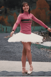 a woman wearing a pink shirt with a gucci logo on it is wearing a white tutu