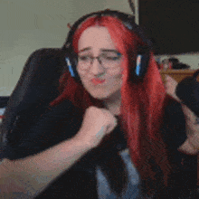 a woman with red hair and glasses wearing headphones