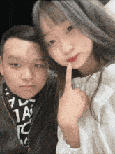 a man and a girl are posing for a picture and the girl is holding her finger to her mouth