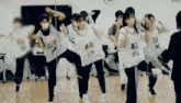 a group of girls are dancing in front of a mirror with one wearing a shirt that says a11