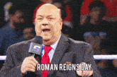 a man in a suit and tie is talking into a microphone with roman reigns day written on it