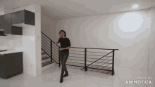 a woman in a black shirt is standing next to a railing in a room that says made in animotica