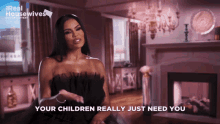 a woman is sitting in front of a fireplace and says " your children really just need you "