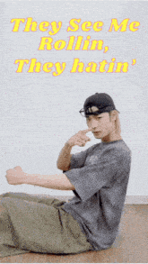 a man sitting on the floor with the words they see me rollin they hatin