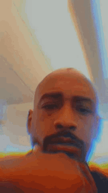 a man with a beard looks at the camera with a blurry background