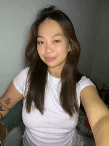 a woman taking a selfie with a tattoo on her arm