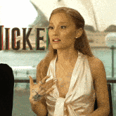 a woman sitting in front of a sign that says icken