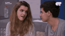 a man and a woman are looking at each other and talking .
