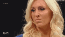 a woman with blonde hair is making a funny face on a television screen .