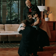 a group of people hugging in a living room