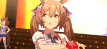a girl with ponytails is holding a red item in her hands