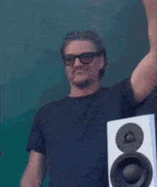 a man wearing sunglasses is holding a colorful light stick over his head
