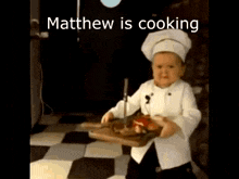a baby in a chef 's hat is holding a cutting board with meat on it .