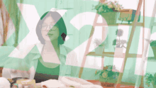 a woman wearing glasses sits in front of a green background with the number x2 on it