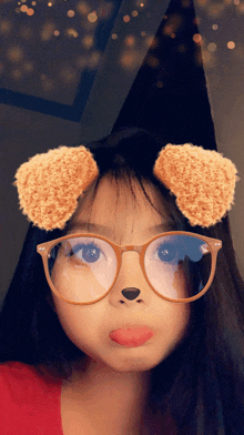a girl wearing glasses and a witch hat makes a face with her tongue out