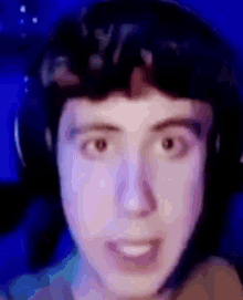 a close up of a person 's face with headphones on and a blue background .