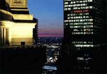 a view of a city at night with a clock on top of a building