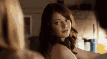 a woman without a shirt is looking at a man in a kitchen .