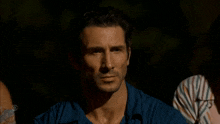 a man in a blue shirt has a cbs logo on his shoulder