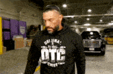 a man wearing a hoodie that says otc chief on it