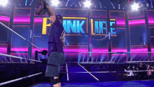 a man in a wrestling ring with the words pink life on the wall behind him