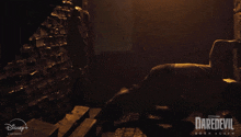 a poster for daredevil born again shows two men fighting in a dark room
