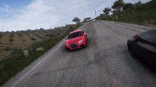 a red audi is driving down a road next to another red car