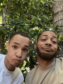 two men making funny faces in front of trees