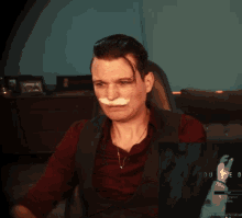 a man with a fake mustache is sitting in front of a screen that says you
