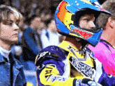 a man wearing a helmet that says fox on it stands next to a woman