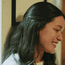a close up of a woman 's face smiling with her eyes closed .