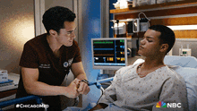 two men in scrubs are talking to a patient in a hospital bed with #chicagomed on the bottom