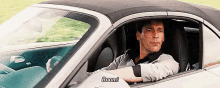 a man is sitting in a car with the word boom written on the side