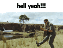 a man is running in a field with the words hell yeah on the bottom