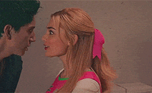 a man with green hair and a woman with blonde hair are looking at each other and talking .