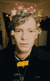 a young man with flowers in his hair and the word cute on his shirt