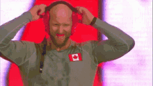 a man wearing headphones has a canadian flag patch on his chest