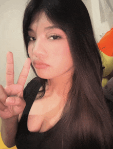 a woman giving a peace sign with her hand