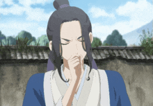 a man covering his mouth with his hand in front of a wall