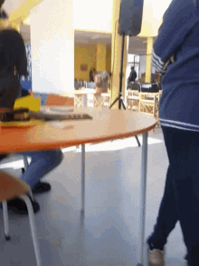 a person standing in front of a table with a speaker on it