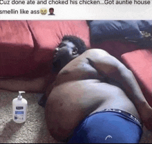 a man is laying on a couch with a bottle of kirkland lotion next to him